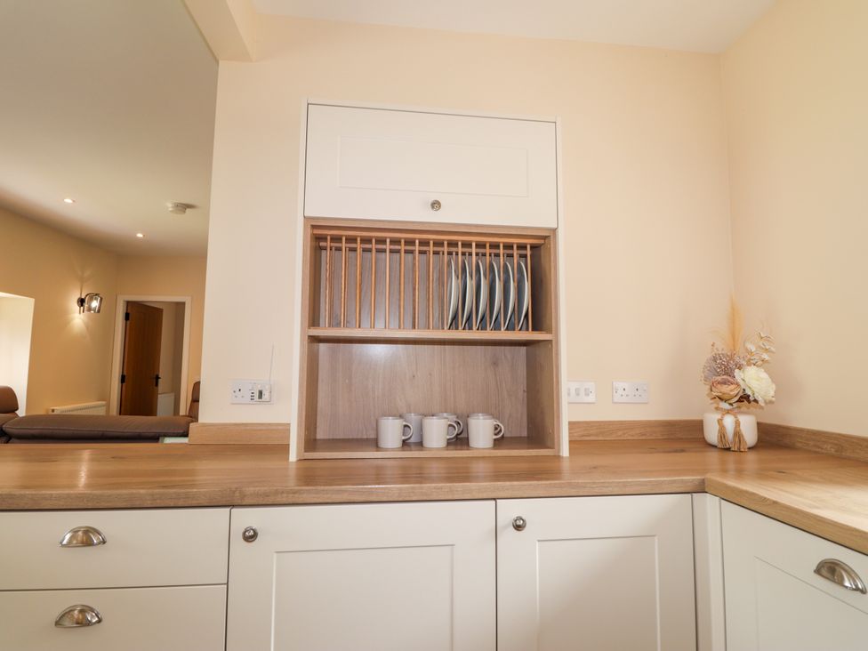 A kitchen with a wall cabinet and countertop at Millmoss Cottage