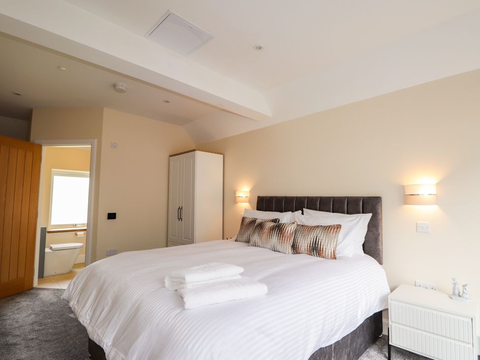 A bedroom with a bed and wardrobe at Millmoss Cottage