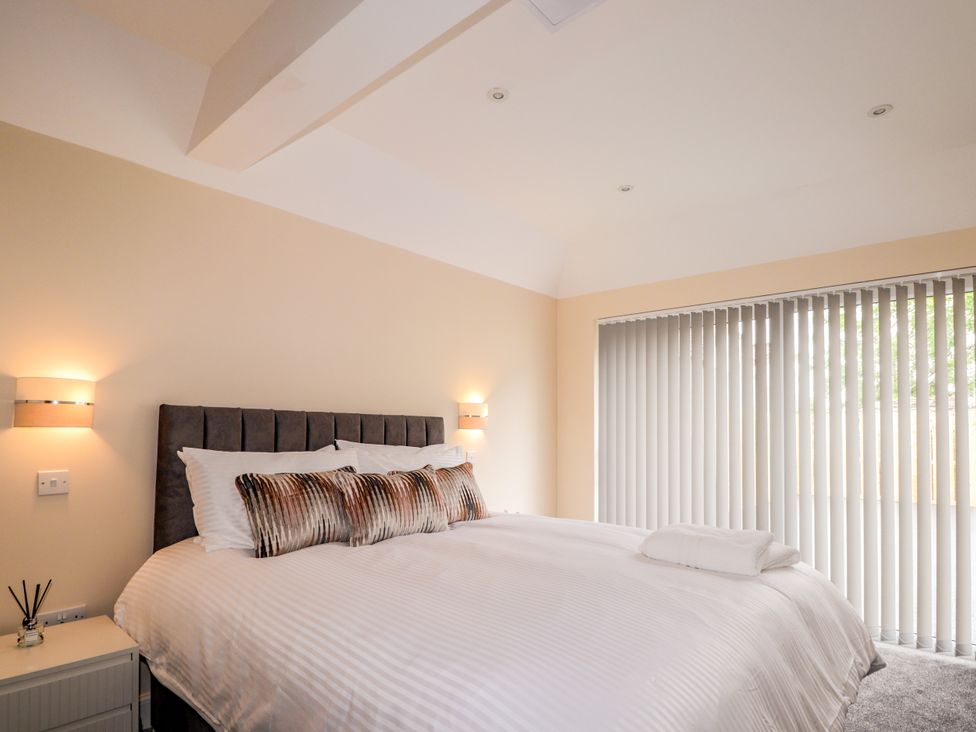 A bedroom with a double bed and bedside lights at Millmoss Cottage