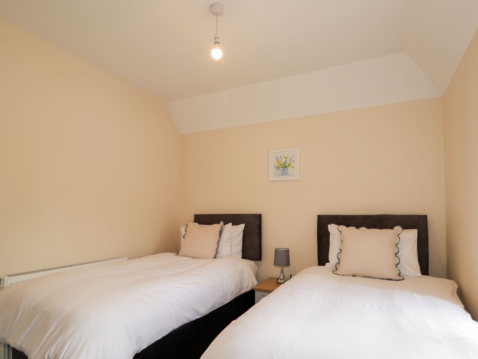 A bedroom with two single beds at Millmoss Cottage