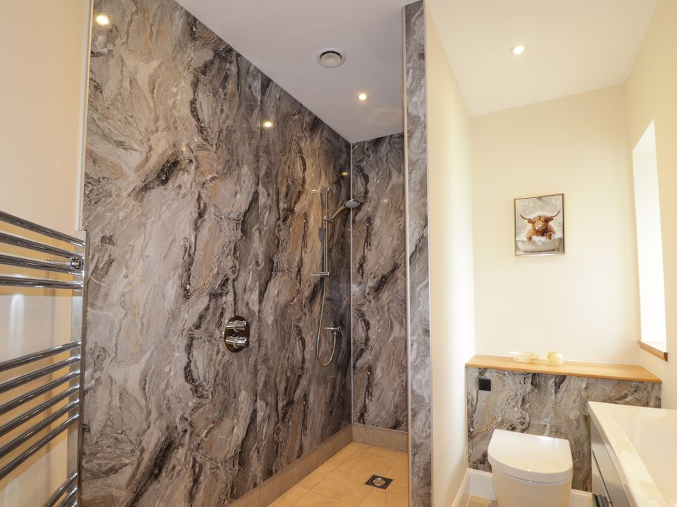 A bathroom with a shower, toilet and sink at Millmoss Cottage