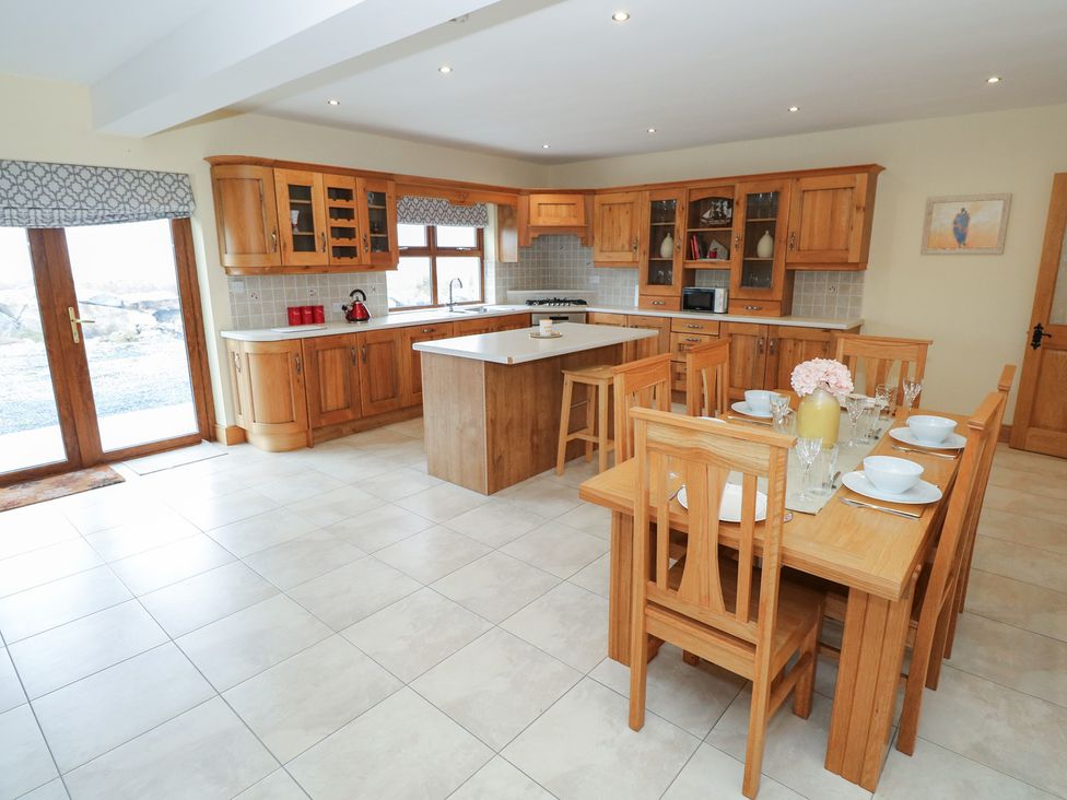 A kitchen with dining area and wooden furniture at Tigh Marie 