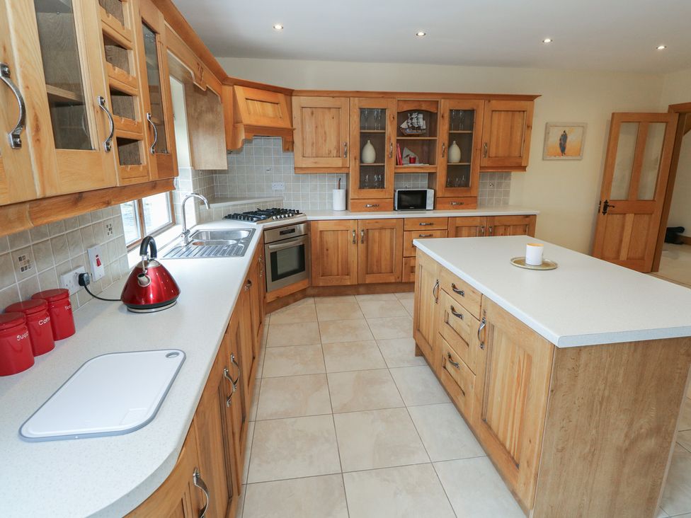 A kitchen with cabinets, sink, stove, and island at Tigh Marie