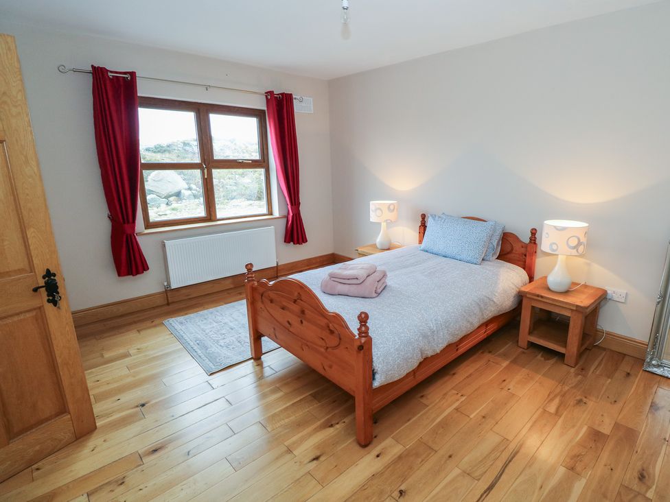 A bedroom with a bed and lamps at Tigh Marie