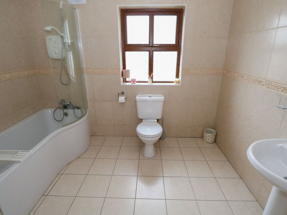 A bathroom with a bathtub, toilet, and sink at Tigh Marie