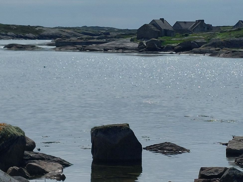 A landscape with water, rocks, and houses at Tigh Marie 
