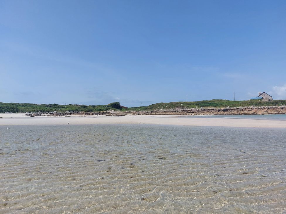 A beach scene with water and a house at Tigh Marie