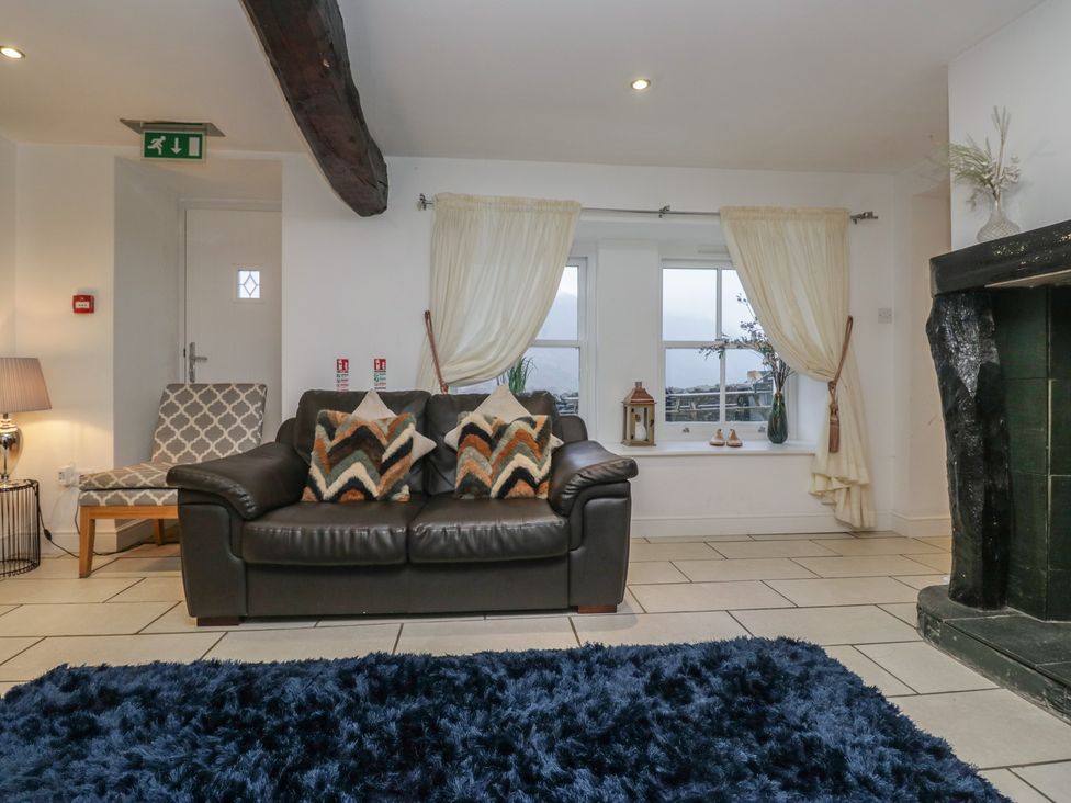 A living room with a sofa, pillows, and a window at Newlands Fell House near Keswick