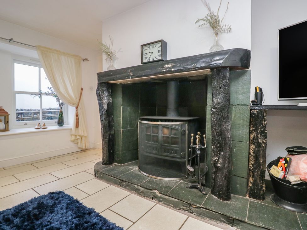 A living room with a fireplace and television at Newlands Fell House in Newlands near Keswick