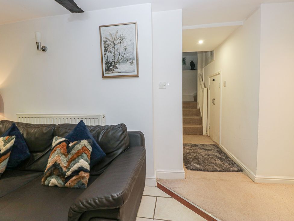 A living room with a sofa and stair access at Newlands Fell House in Newlands near Keswick
