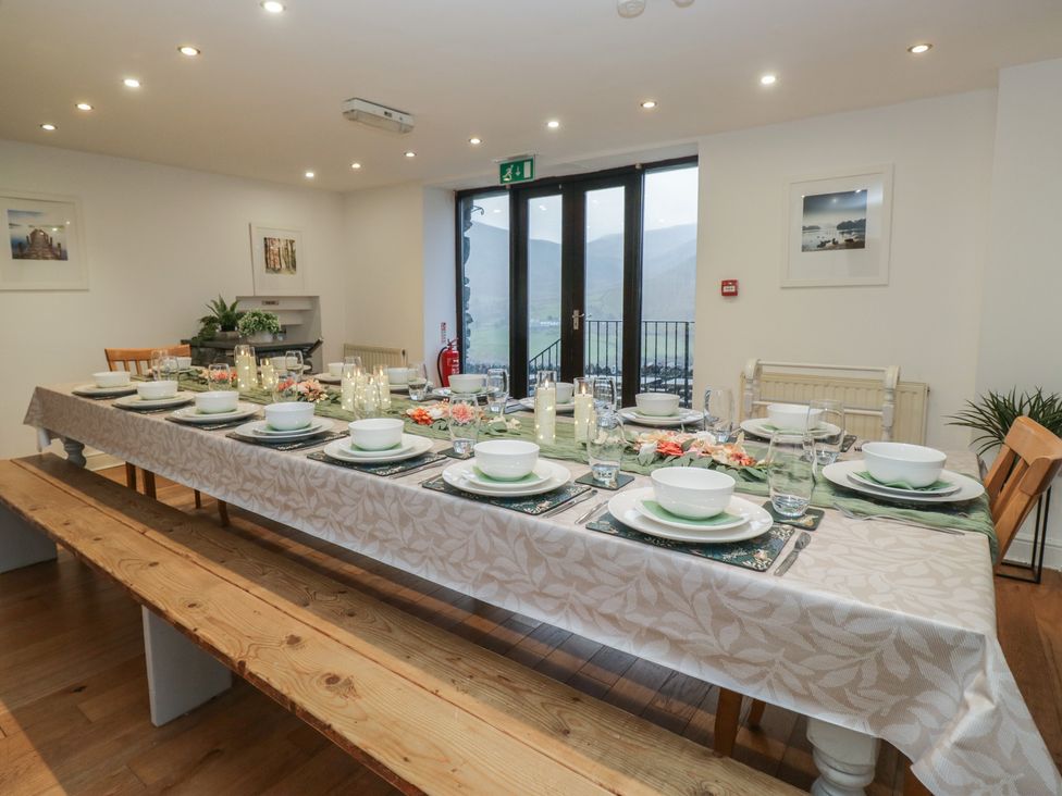 A dining room with a long table set for a meal at Newlands Fell House in Newlands near Keswick