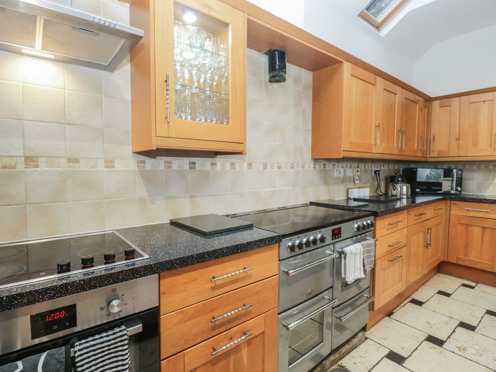 A kitchen with cabinets and appliances at Newlands Fell House in Newlands near Keswick