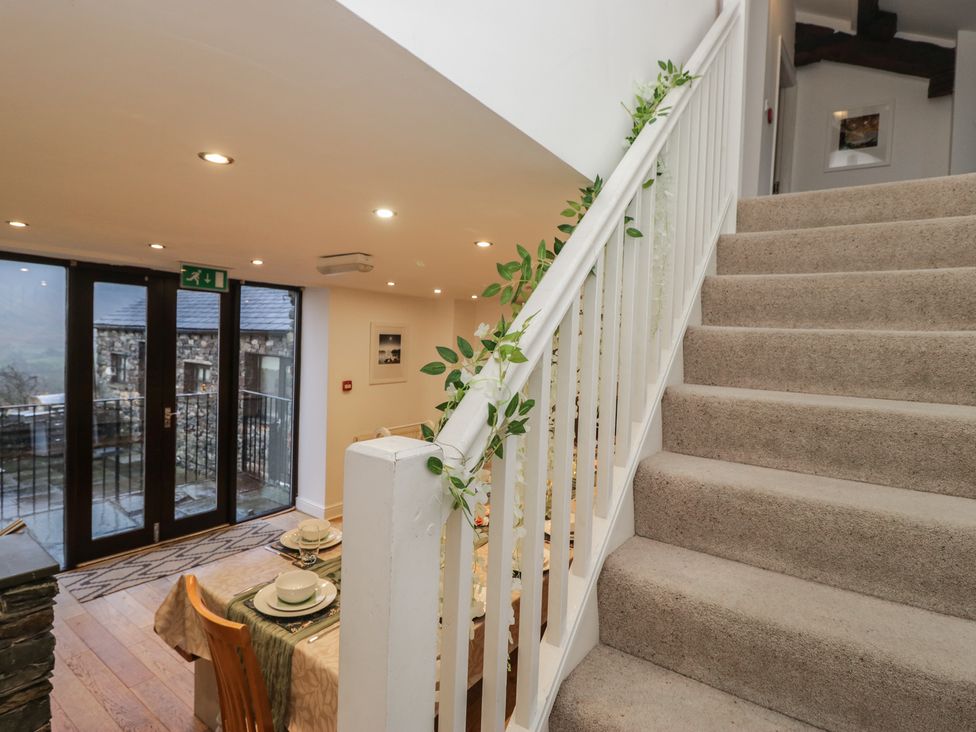 A dining room with staircase and sliding door at Newlands Fell House, Newlands near Keswick