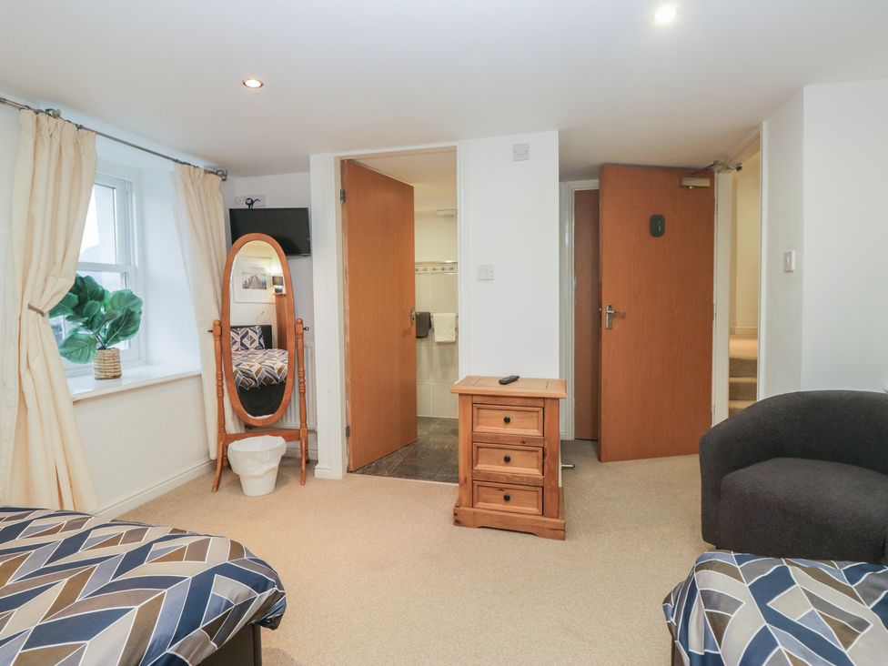 A bedroom with two beds and a mirror at Newlands Fell House in Newlands near Keswick