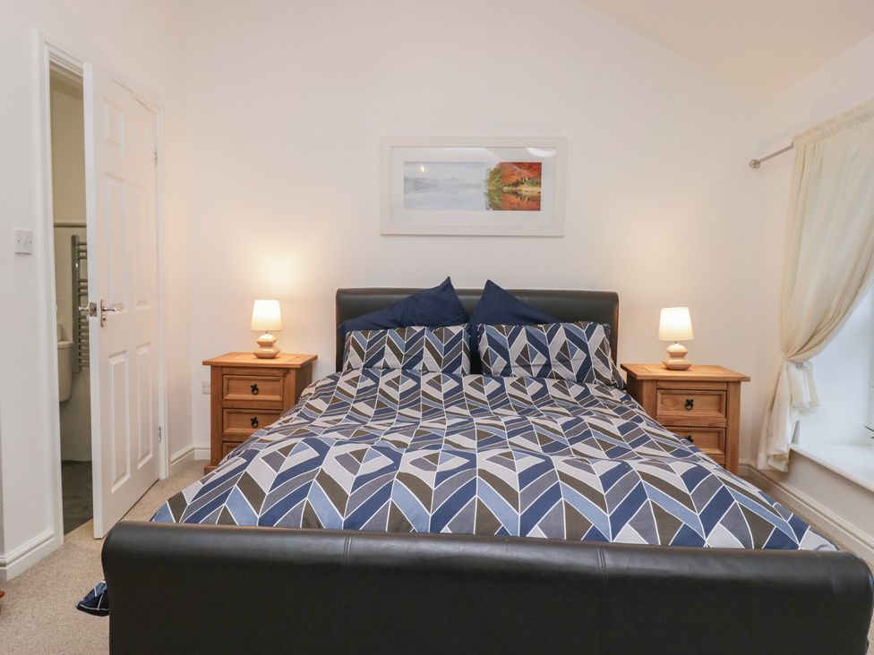 A bedroom with a bed and bedside tables at Newlands Fell House in Newlands near Keswick