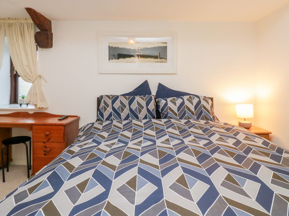 A bedroom with a bed and desk at Newlands Fell House in Newlands near Keswick