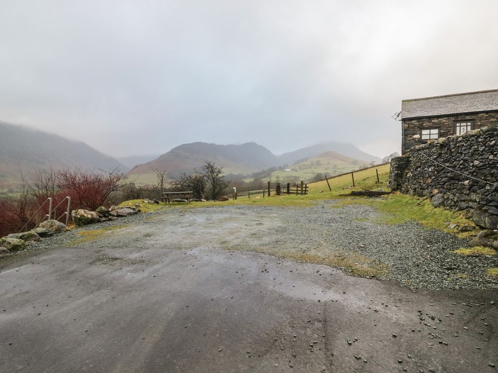 A view of mountains and fields from a gravel area at Newlands Fell House in Newlands near Keswick