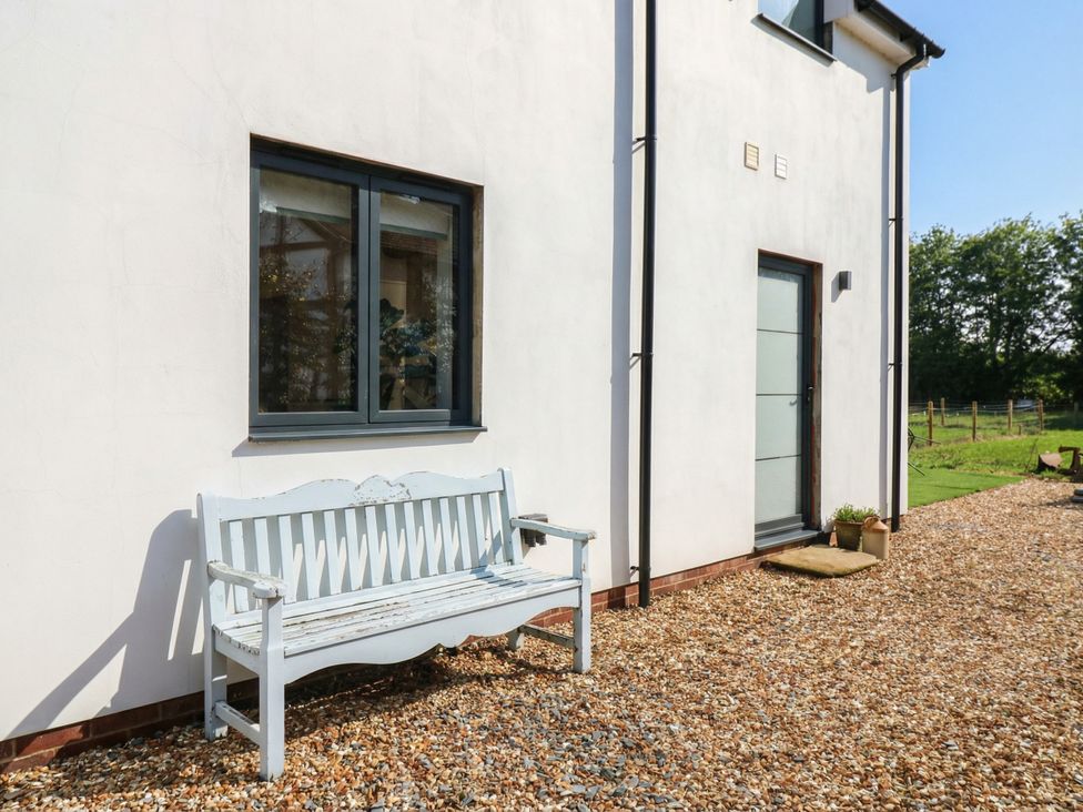 A bench and window outside a house at The Kiln in Colmworth