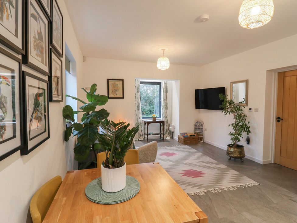 A living room with a table, chairs, and a plant at The Kiln in Colmworth
