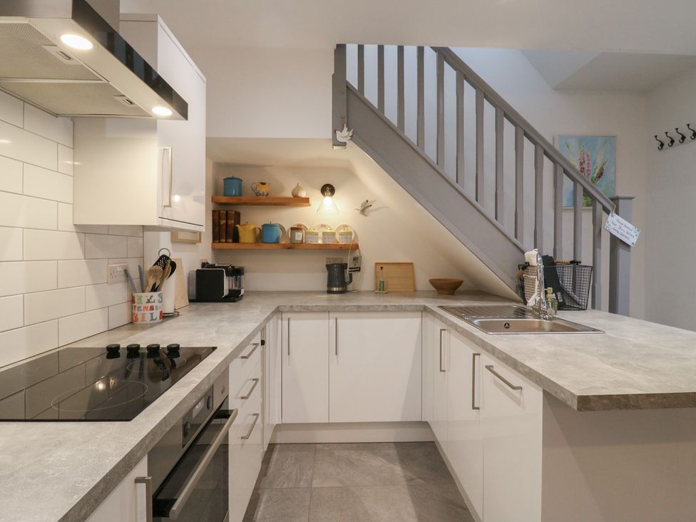 A kitchen with stove, sink, and shelves at The Kiln in Colmworth