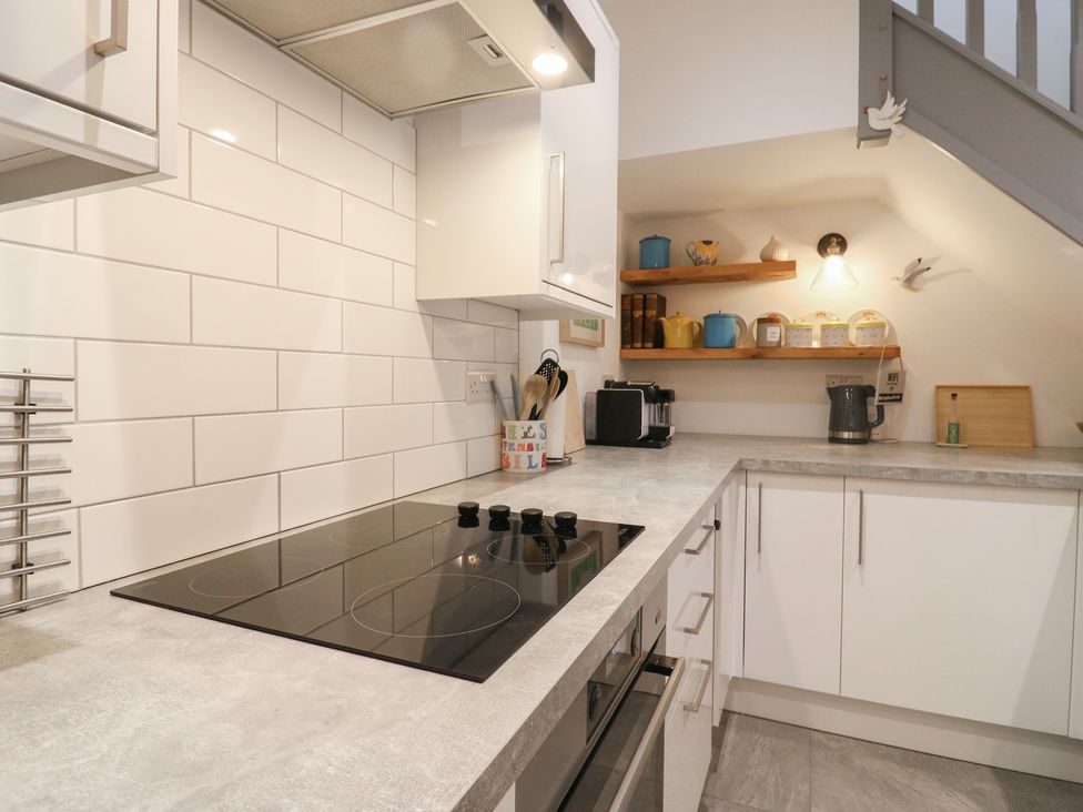 A kitchen with a cooker and shelves at The Kiln in Colmworth