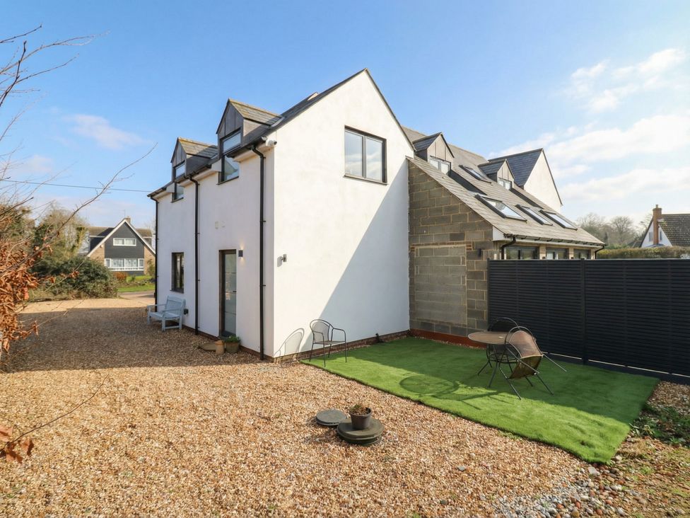 A house exterior with gravel pathway and seating area at The Kiln in Colmworth