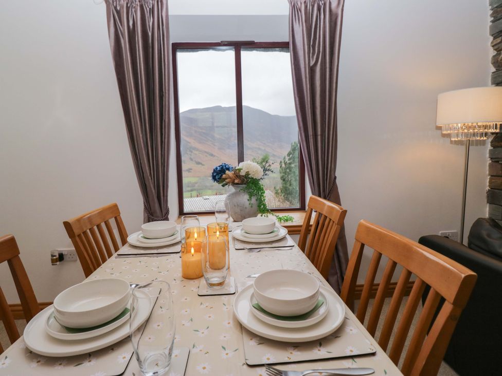 A dining room with a table set for dinner at Newlands Fell Cottage near Keswick