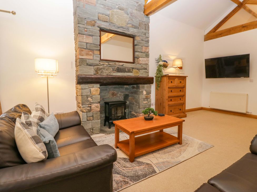A living room with a fireplace and furniture at Newlands Fell Cottage in Newlands near Keswick