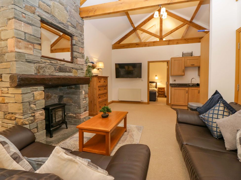 A living room with a sofa, coffee table, and fireplace at Newlands Fell Cottage in Newlands near Keswick