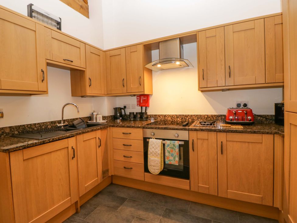 A kitchen with countertops, cabinets, sink, oven, and appliances at Newlands Fell Cottage near Keswick