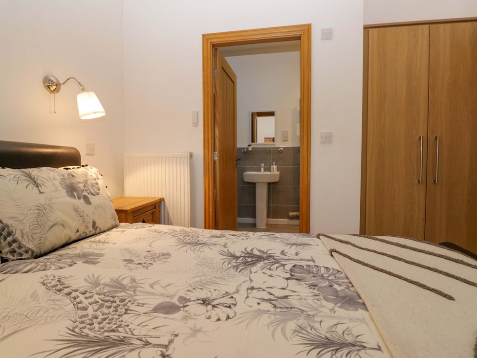 A bedroom with a bed and a view to a washroom at Newlands Fell Cottage in Newlands near Keswick