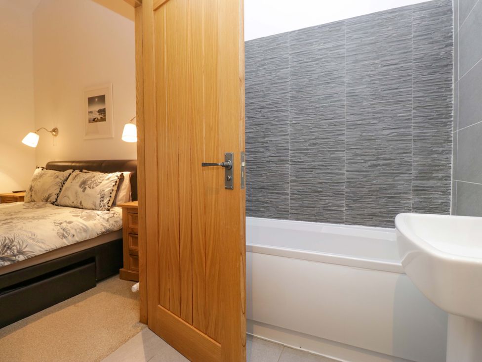 A bedroom with a bed and an adjoining bathroom at Newlands Fell Cottage in Newlands near Keswick