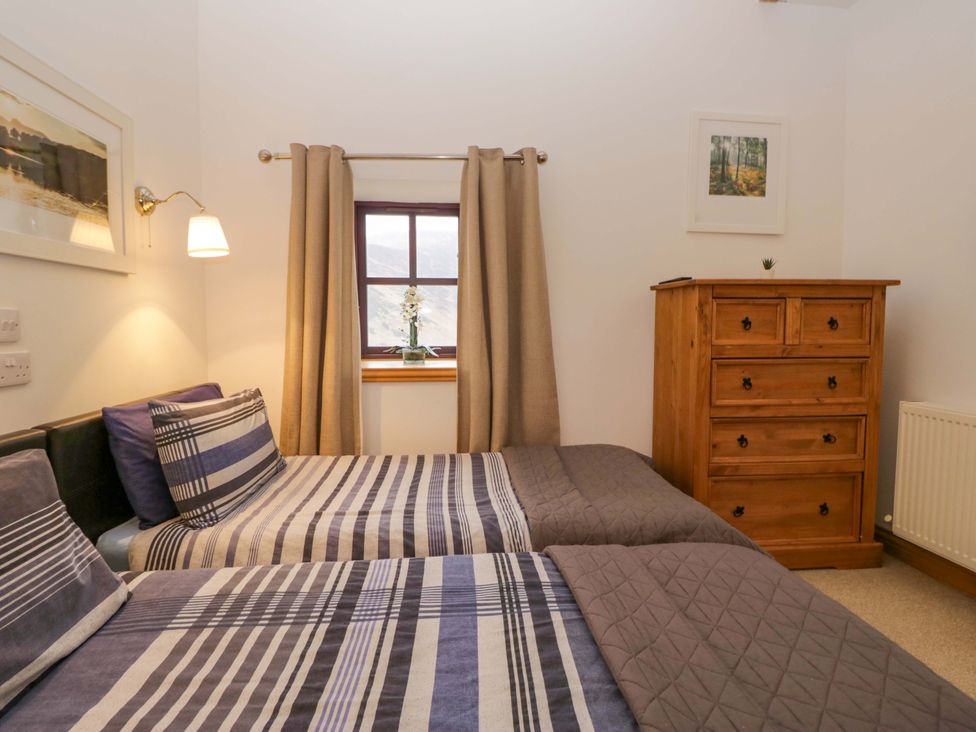 A bedroom with two beds and a chest of drawers at Newlands Fell Cottage in Newlands near Keswick