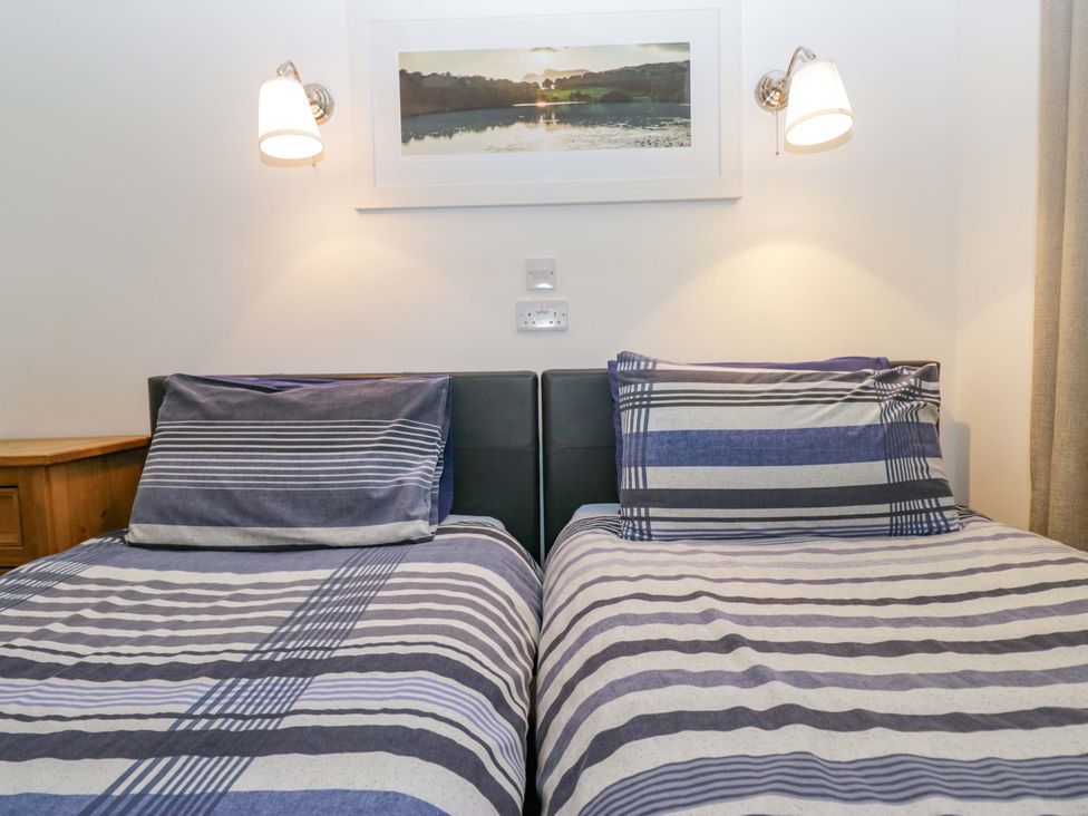 A bedroom with two beds and wall art at Newlands Fell Cottage in Newlands near Keswick