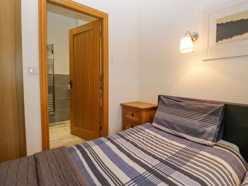 A bedroom with a bed and door at Newlands Fell Cottage in Newlands near Keswick