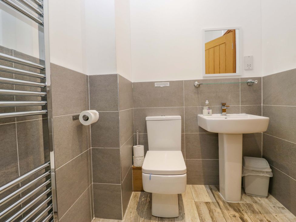 A bathroom with a toilet, sink, and towel rail at Newlands Fell Cottage near Keswick