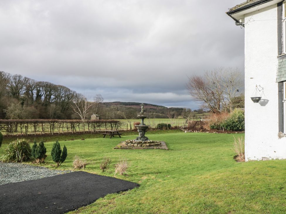 A garden with a fountain and bench at Herdwick Croft in Bassenthwaite