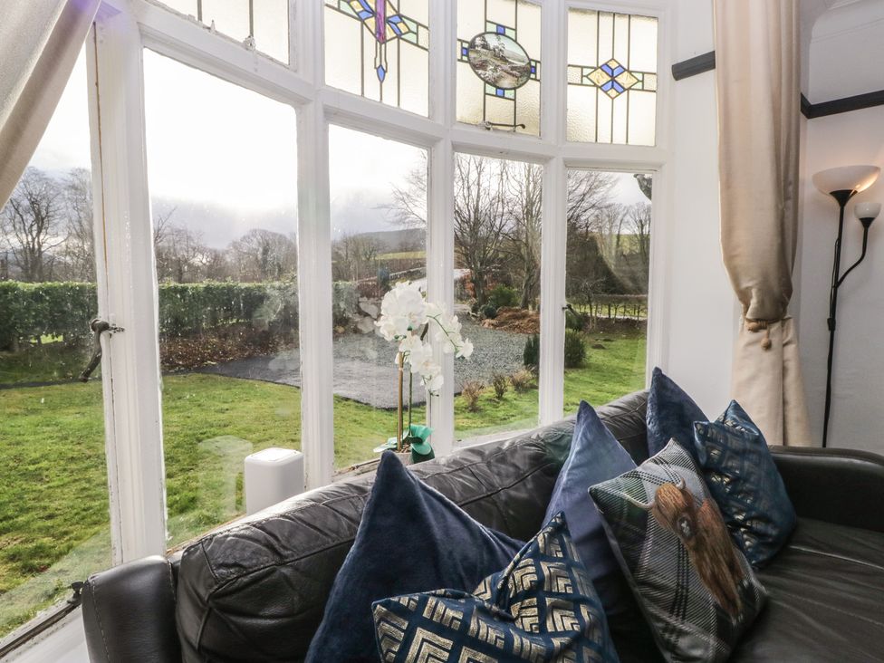 A living room with a view through a large window at Herdwick Croft in Bassenthwaite