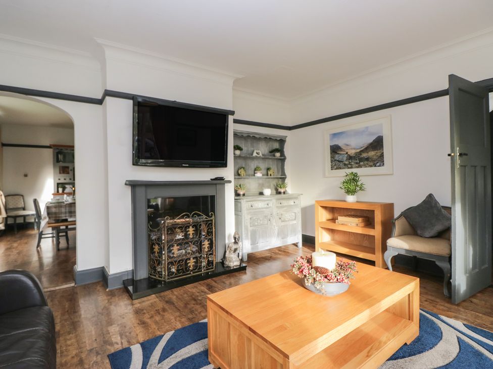 A living room with a television and fireplace at Herdwick Croft in Bassenthwaite
