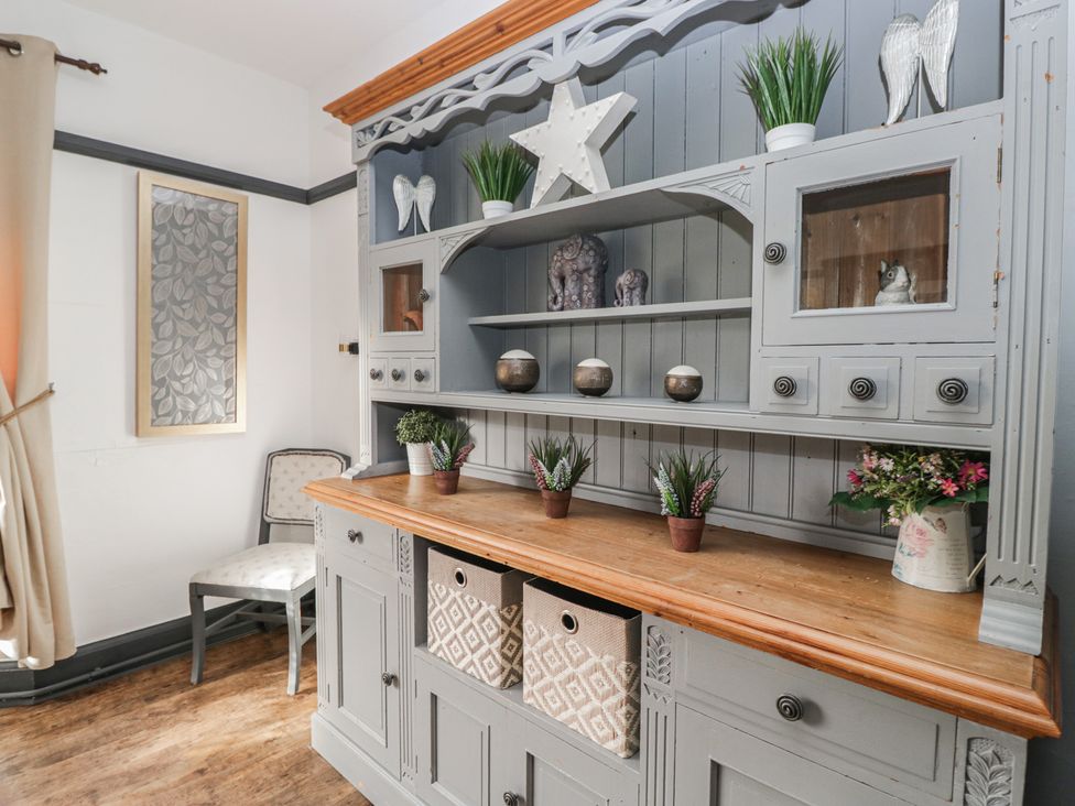 A cabinet with shelves and decorative items at Herdwick Croft in Bassenthwaite