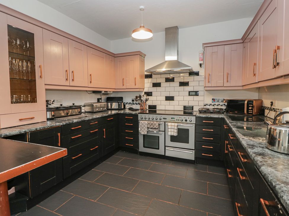 A kitchen with cabinets, oven, sink and countertop at Herdwick Croft in Bassenthwaite