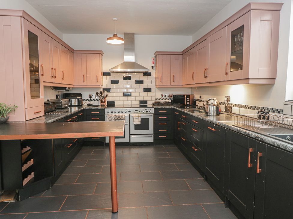 A kitchen with a stove refrigerator and countertop at Herdwick Croft in Bassenthwaite