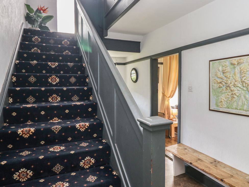 A hallway with stairs and a map on the wall at Herdwick Croft in Bassenthwaite