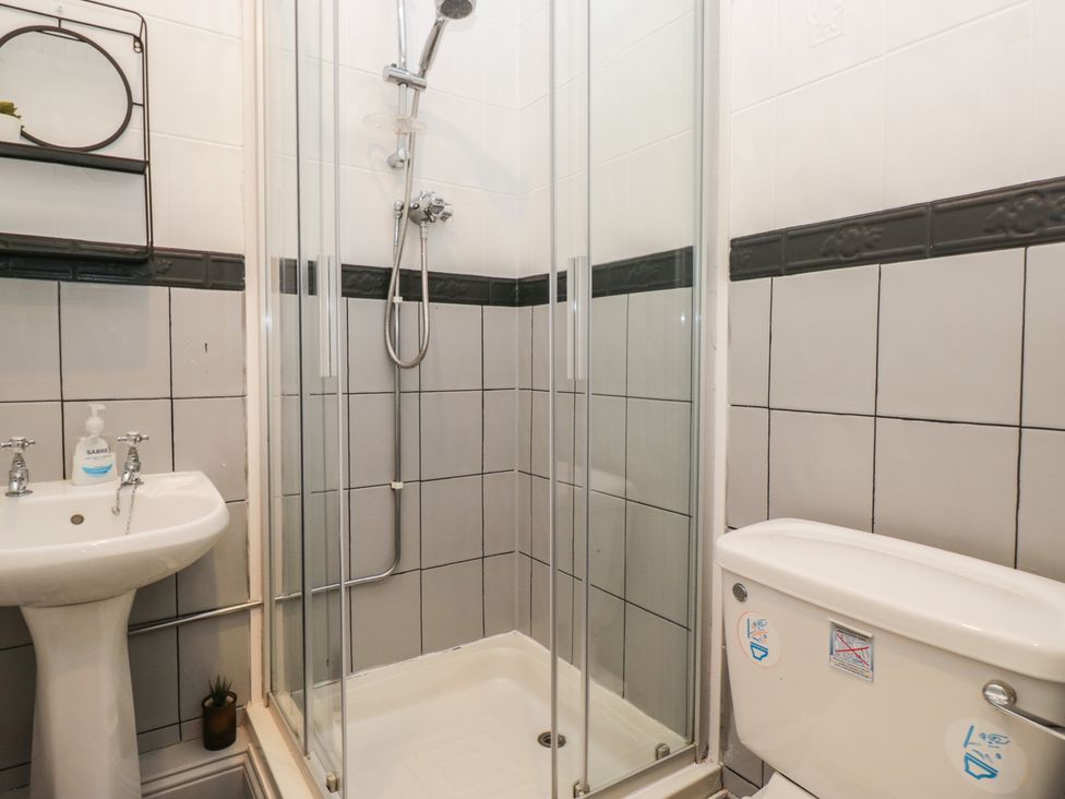 A bathroom with a shower, toilet, and sink at Herdwick Croft in Bassenthwaite