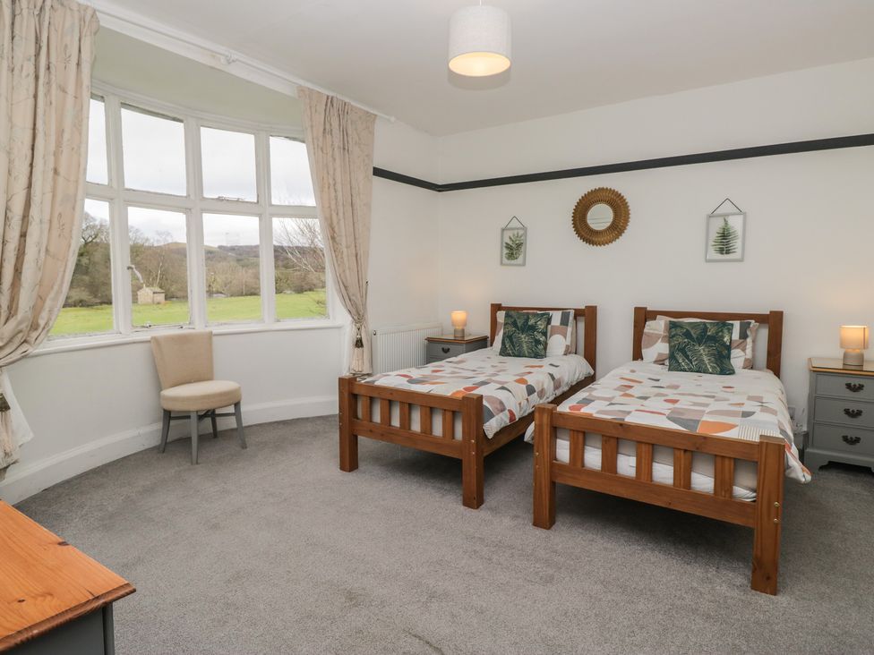 A bedroom with two single beds and a chair at Herdwick Croft in Bassenthwaite