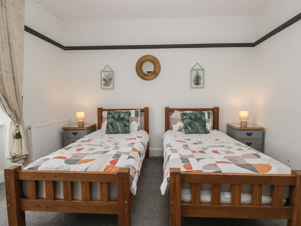 A bedroom with two single beds and nightstands at Herdwick Croft in Bassenthwaite
