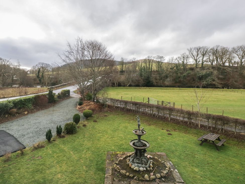 A garden with a fountain and a bench at Herdwick Croft in Bassenthwaite