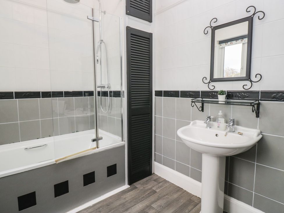 A bathroom featuring a bathtub with a shower and a sink at Herdwick Croft in Bassenthwaite
