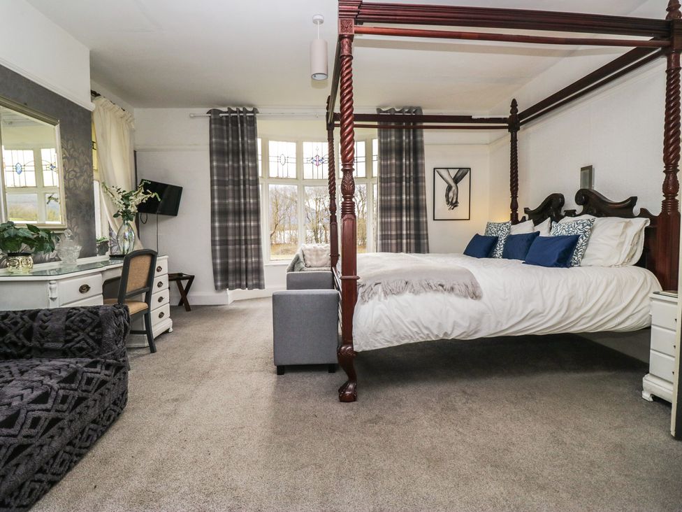 A bedroom with a four-poster bed and a dressing table at Herdwick Croft in Bassenthwaite