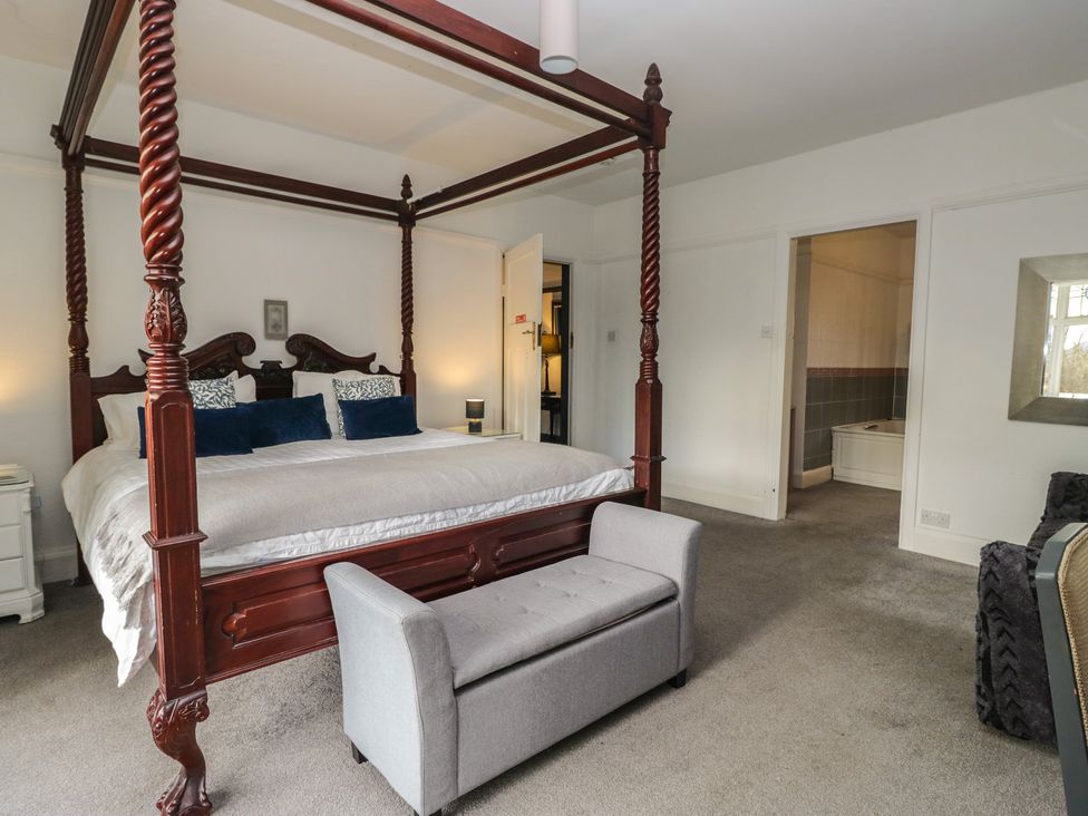 A bedroom with a four-poster bed and a couch at Herdwick Croft in Bassenthwaite